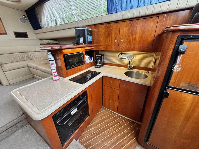 Slide: The Image of Luxurious 2004 Cruisers Yachts 375 Motoryacht kitchen with wood cabinetry and modern appliances. - 28