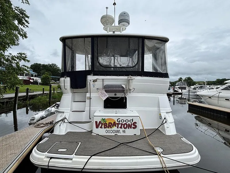 Slide: The Image of 2004 Cruisers Yachts 375 Motoryacht docked, rear view with "Good Vibrations" signage. - 3