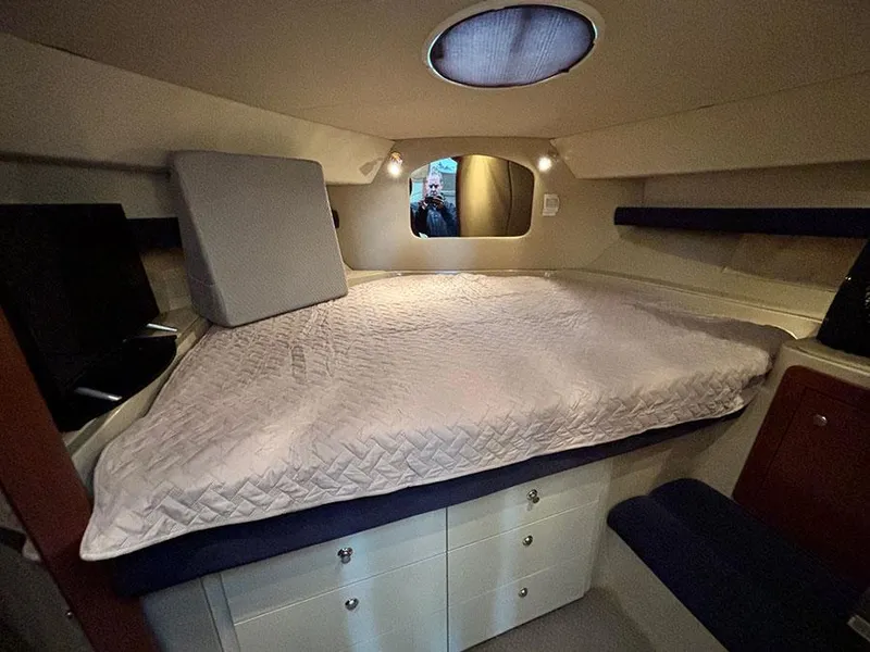Slide: The Image of 2004 Cruisers Yachts 375 Motoryacht cabin with bed, storage, and porthole. - 32