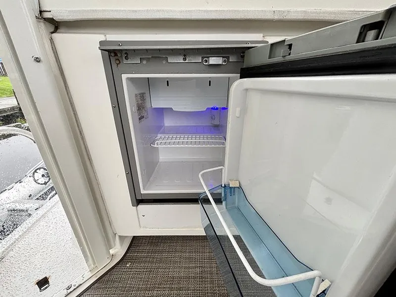 Slide: The Image of Open mini fridge on 2004 Cruisers Yachts 375 Motoryacht, showing interior shelving. - 9
