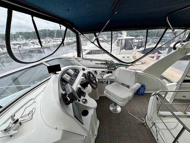 Slide: The Image of 2004 Cruisers Yachts 375 Motoryacht helm with white seating and marina view. - 13