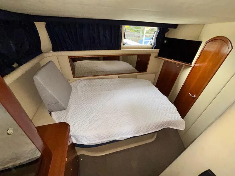 Slide: The Image of 2004 Cruisers Yachts 375 Motoryacht bedroom with bed, TV, and window view. - 16
