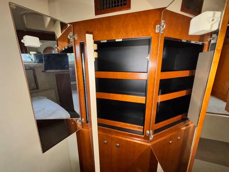 Slide: The Image of 2004 Cruisers Yachts 375 Motoryacht interior with open wooden cabinets and mirrored doors. - 19