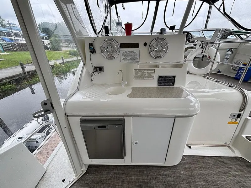 Slide: The Image of 2004 Cruisers Yachts 375 Motoryacht interior with sink, mini fridge, and control panel. - 8
