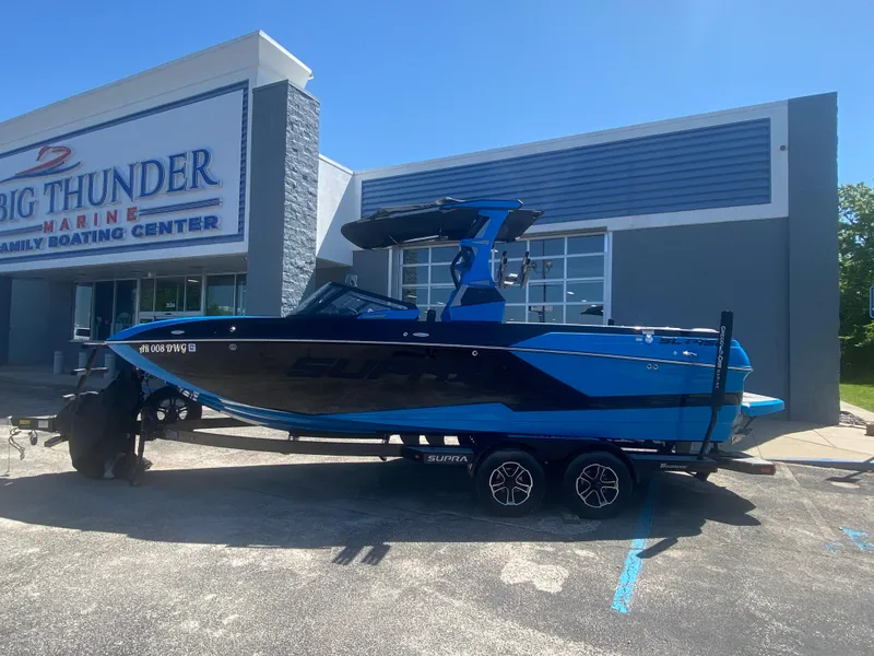 Slide: The Image of 2021 Supra SL 450 boat in blue, parked at Big Thunder Marine. - 1