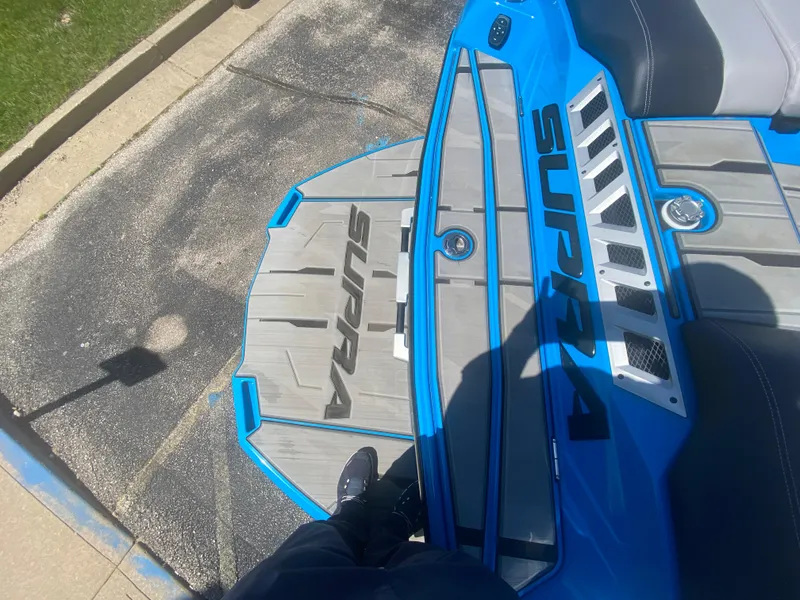 Slide: The Image of 2021 Supra SL 450 boat deck with blue accents and branding. - 10