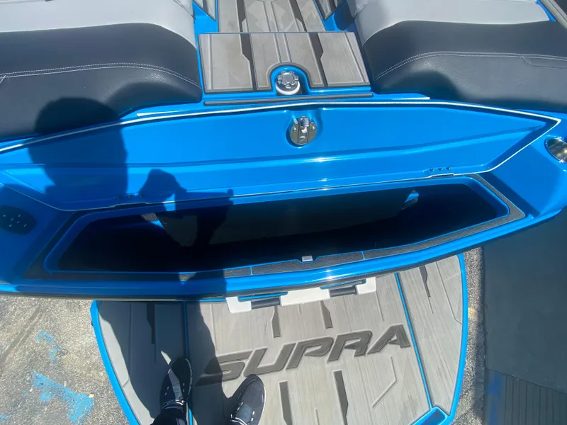 Slide: The Image of 2021 Supra SL 450 boat interior with blue accents and open storage compartment. - 11