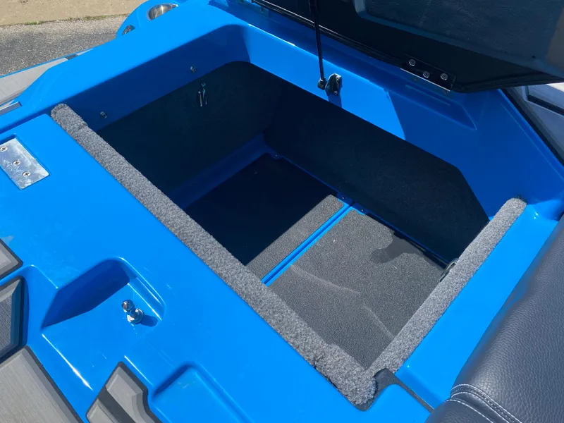 Slide: The Image of Open storage compartment of a 2021 Supra SL 450 boat, featuring a blue interior. - 14