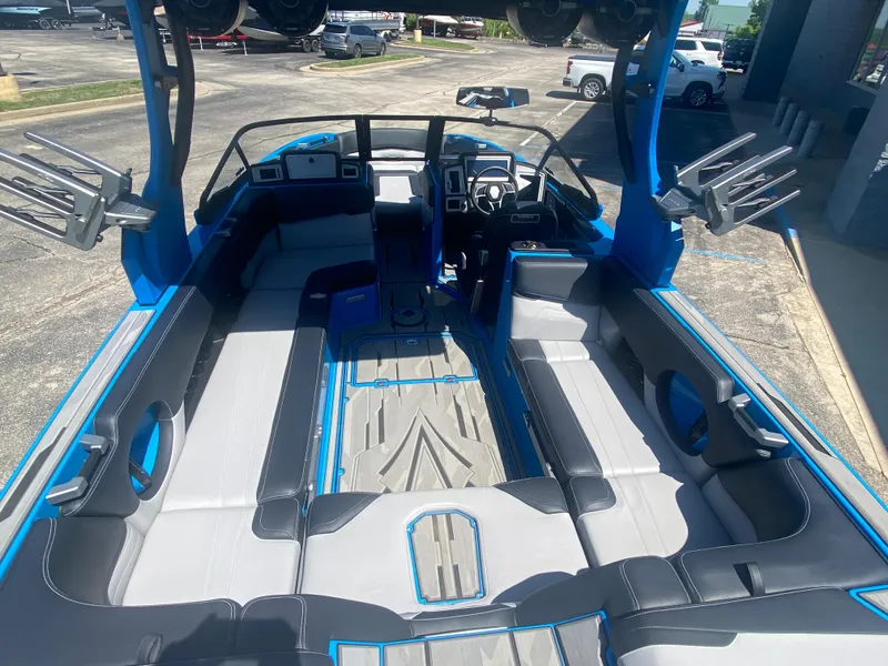 Slide: The Image of 2021 Supra SL 450 boat interior with blue and gray seating, steering wheel, and wakeboard racks. - 15
