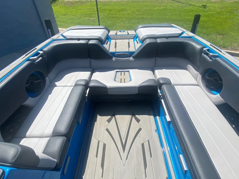 Slide: The Image of 2021 Supra SL 450 boat interior with gray and black seating, blue accents, and modern design. - 16