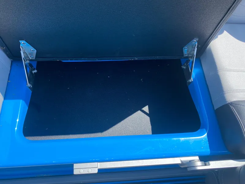 Slide: The Image of Open storage compartment in 2021 Supra SL 450 boat, featuring blue interior. - 24