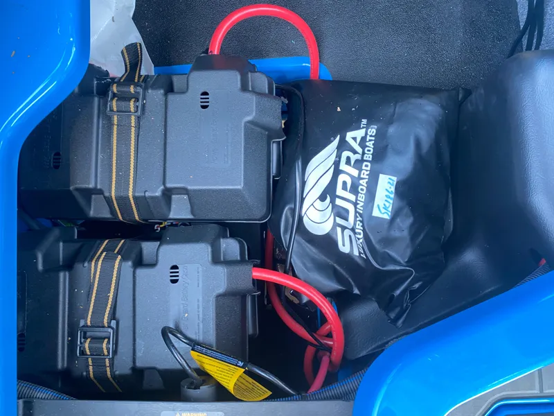 Slide: The Image of Two battery boxes and Supra branded bag in a 2021 Supra SL 450 boat. - 27