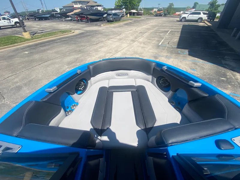 Slide: The Image of 2021 Supra SL 450 boat interior with blue and gray seating in a parking lot. - 29