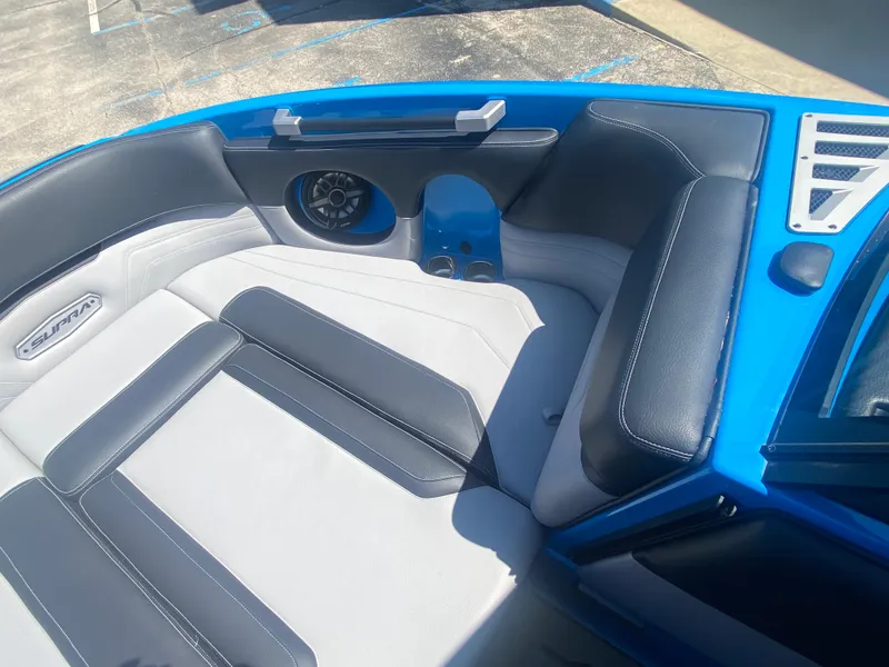 Slide: The Image of 2021 Supra SL 450 boat interior with blue and gray seating, speaker, and storage. - 31