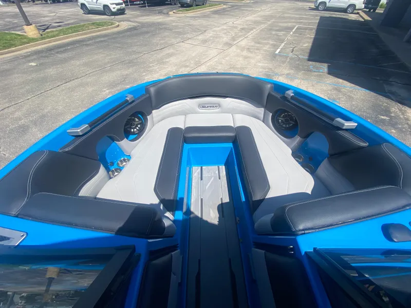 Slide: The Image of 2021 Supra SL 450 boat interior with blue and gray seating in a parking lot. - 32