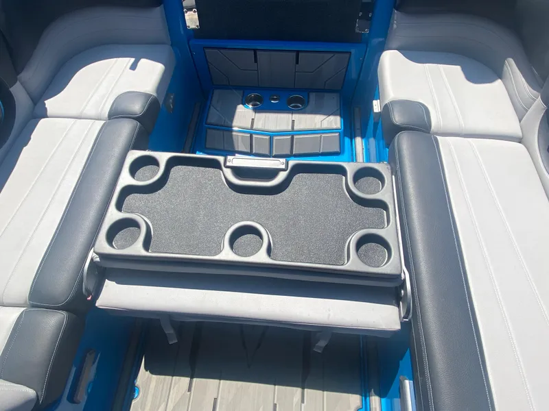 Slide: The Image of 2021 Supra SL 450 interior with gray and black seating, cup holders, and storage compartments. - 34