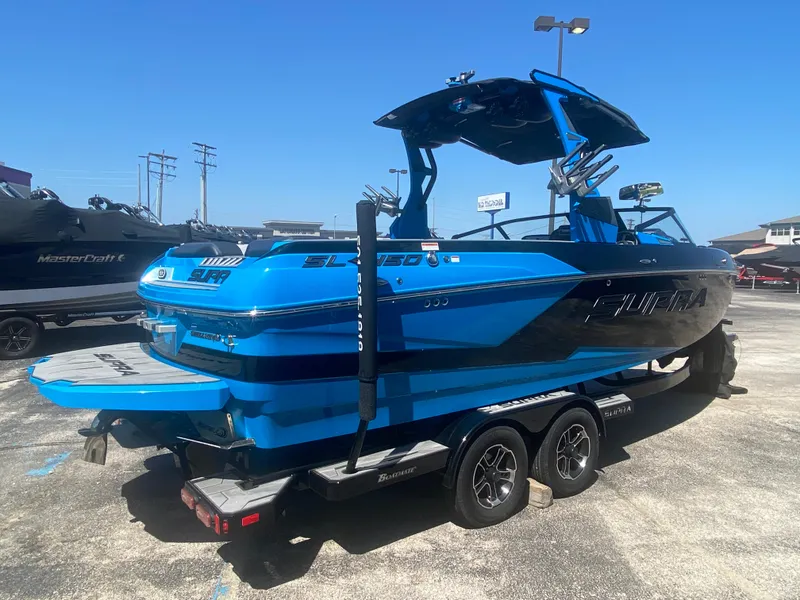 Slide: The Image of Blue 2021 Supra SL 450 boat on trailer in parking lot, sunny day. - 5