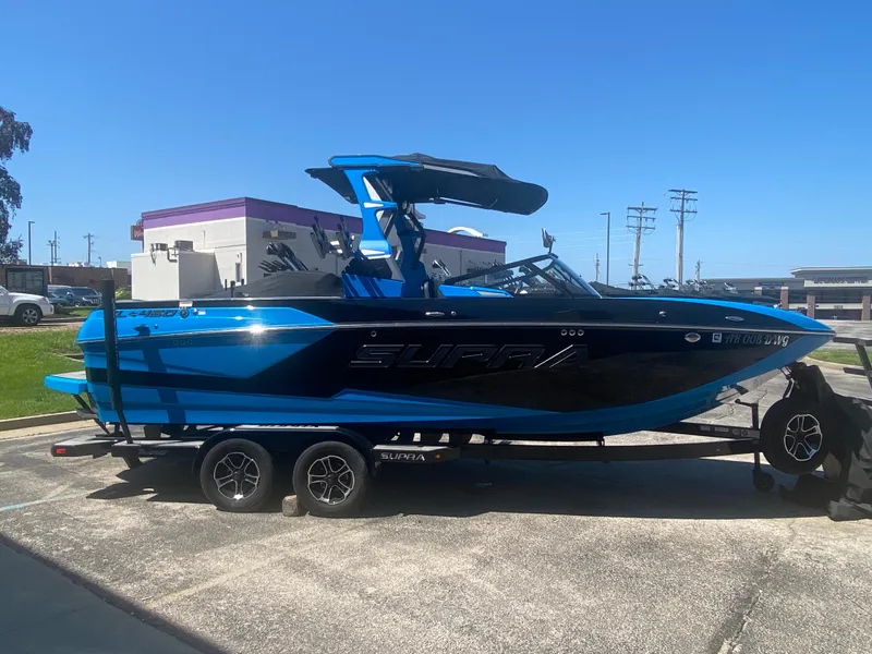 Slide: The Image of 2021 Supra SL 450 boat in blue and black on a trailer, parked outdoors. - 6