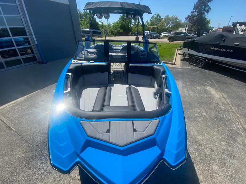 Slide: The Image of 2021 Supra SL 450 boat in vibrant blue, parked outdoors on a sunny day. - 9