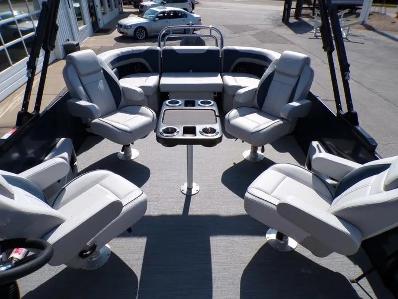 Slide: The Image of 2025 Godfrey Sweetwater 2486 QS iMPACT pontoon boat interior with plush seating and table. - 10