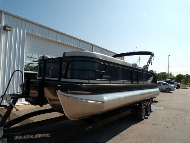 Slide: The Image of 2025 Godfrey Sweetwater 2486 QS iMPACT pontoon boat on trailer, parked outdoors. - 5