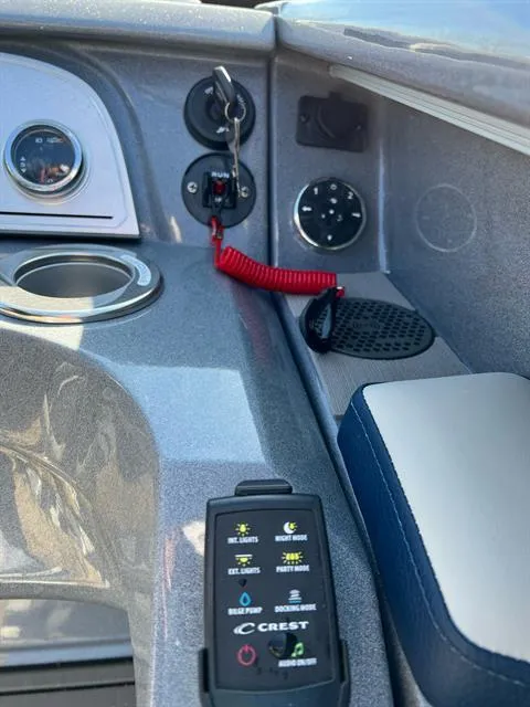 Slide: The Image of Control panel of 2023 Crest Continental 250 boat with key and cup holder. - 14