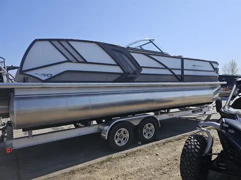 Slide: The Image of 2023 Crest Continental 250 pontoon boat on a trailer, parked outdoors. - 2