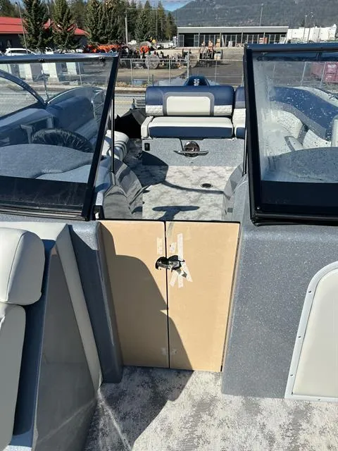 Slide: The Image of 2023 Crest Continental 250 boat interior with seating and windshield, docked outdoors. - 23