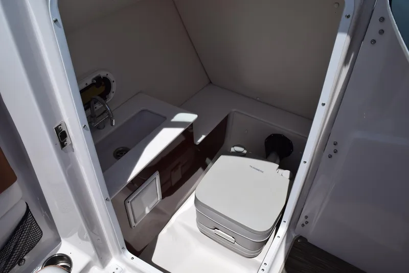 Slide: The Image of 2018 Four Winns HD240 OB boat interior with compact sink and portable toilet. - 8