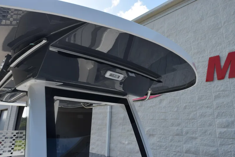 Slide: The Image of 2025 Hurricane Center Console 24 OB boat with sleek T-top design against a building backdrop. - 15