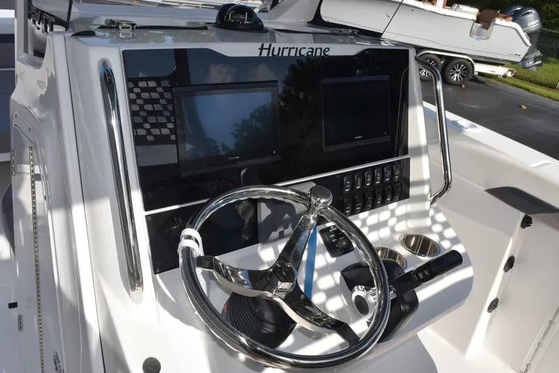 Slide: The Image of 2025 Hurricane Center Console 24 OB boat dashboard with steering wheel and dual screens. - 23