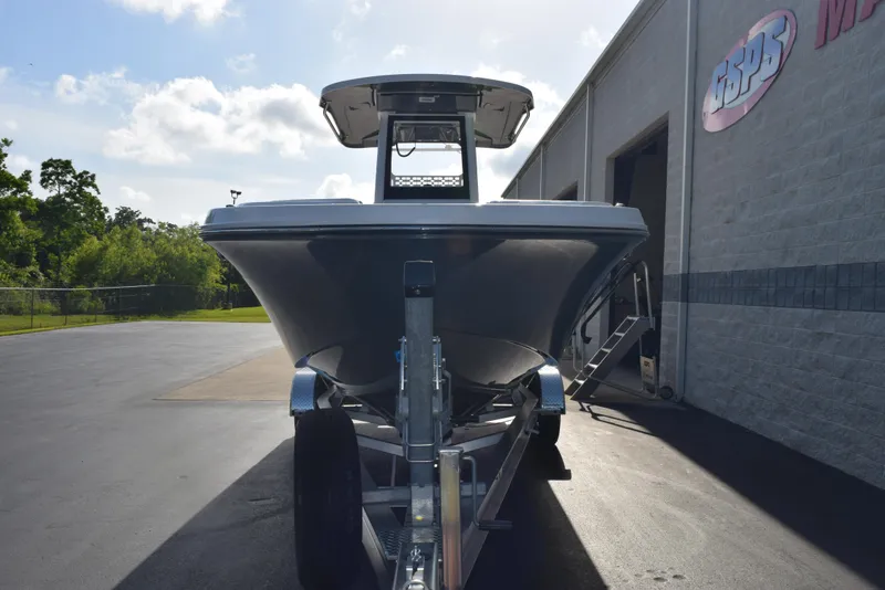 Slide: The Image of 2025 Hurricane Center Console 24 OB boat on trailer, parked outside a building. - 3