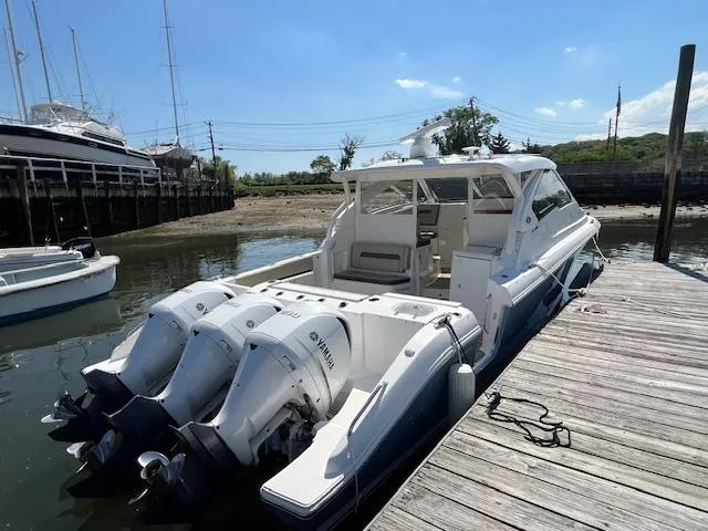 Slide: The Image of 2019 Pursuit DC 365 Dual Console boat docked with triple Yamaha outboard engines. - 10