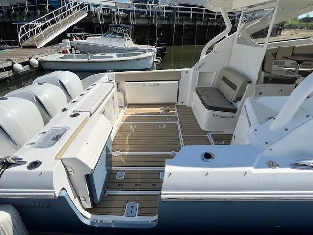 Slide: The Image of 2019 Pursuit DC 365 Dual Console boat with spacious deck and seating at a marina. - 14