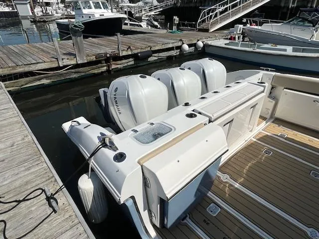 Slide: The Image of 2019 Pursuit DC 365 Dual Console boat docked with triple Yamaha outboard engines. - 15