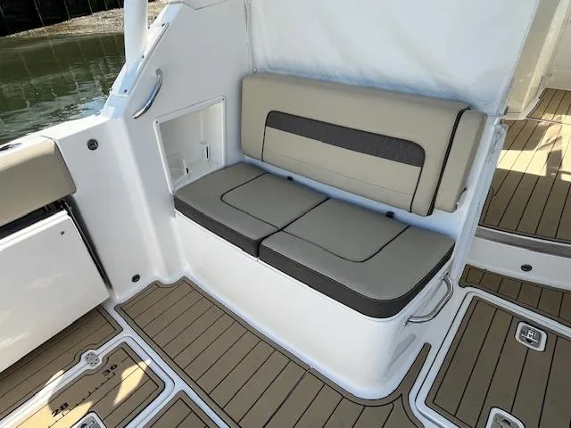 Slide: The Image of 2019 Pursuit DC 365 Dual Console boat seating with beige cushions and teak flooring. - 16