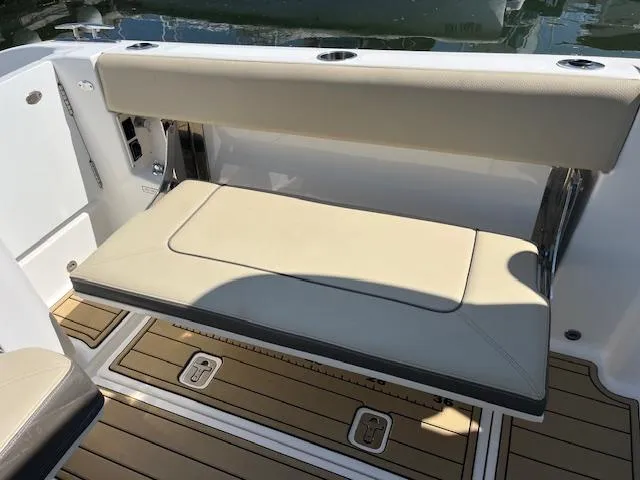 Slide: The Image of 2019 Pursuit DC 365 Dual Console boat with beige seating and teak flooring. - 18