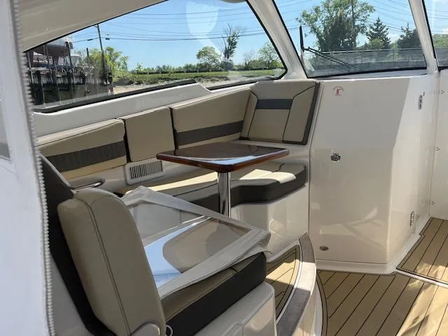 Slide: The Image of 2019 Pursuit DC 365 Dual Console interior with seating and table, featuring modern design and comfort. - 21