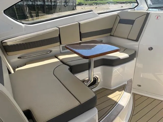 Slide: The Image of 2019 Pursuit DC 365 Dual Console interior with beige seating and wooden table. - 22