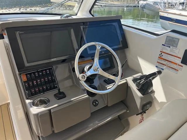Slide: The Image of 2019 Pursuit DC 365 Dual Console helm with steering wheel and control panel. - 24