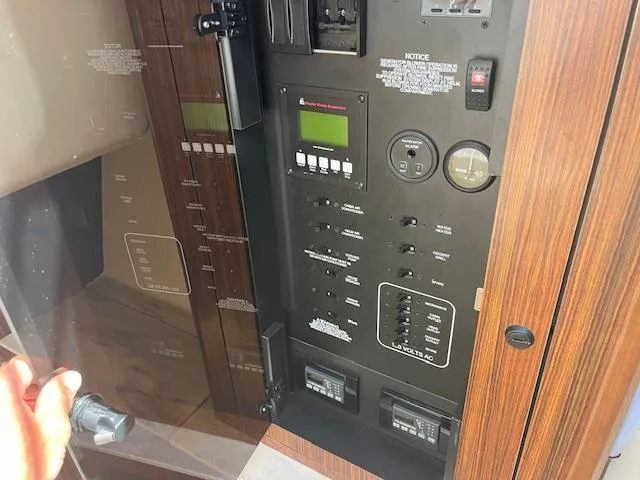 Slide: The Image of Control panel of a 2019 Pursuit DC 365 Dual Console boat, featuring various switches and displays. - 32