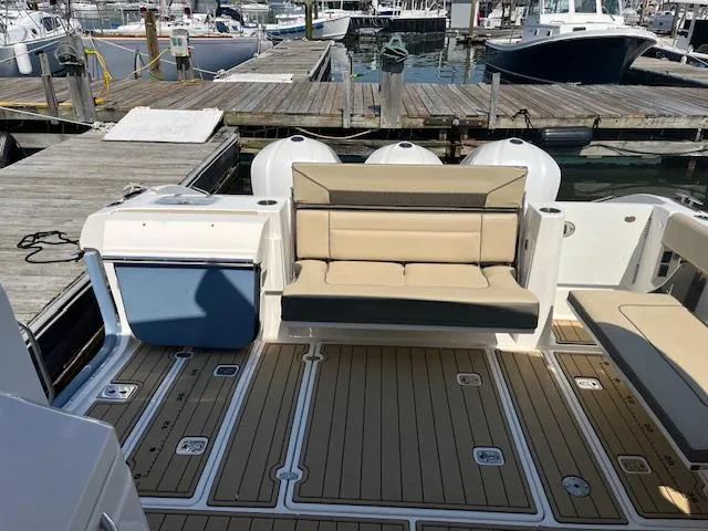 Slide: The Image of 2019 Pursuit DC 365 Dual Console boat interior with seating and deck at marina. - 38