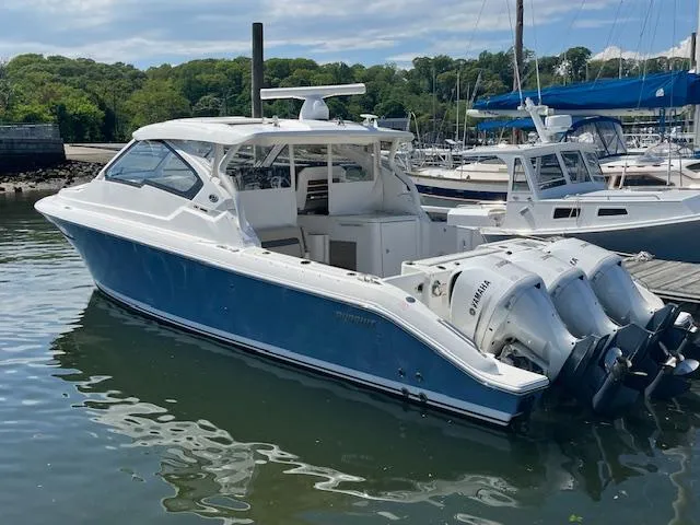 Slide: The Image of 2019 Pursuit DC 365 Dual Console boat docked with triple Yamaha outboard engines. - 5