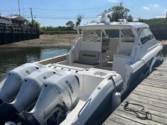 Slide: The Image of 2019 Pursuit DC 365 Dual Console boat docked with triple Yamaha engines. - 9