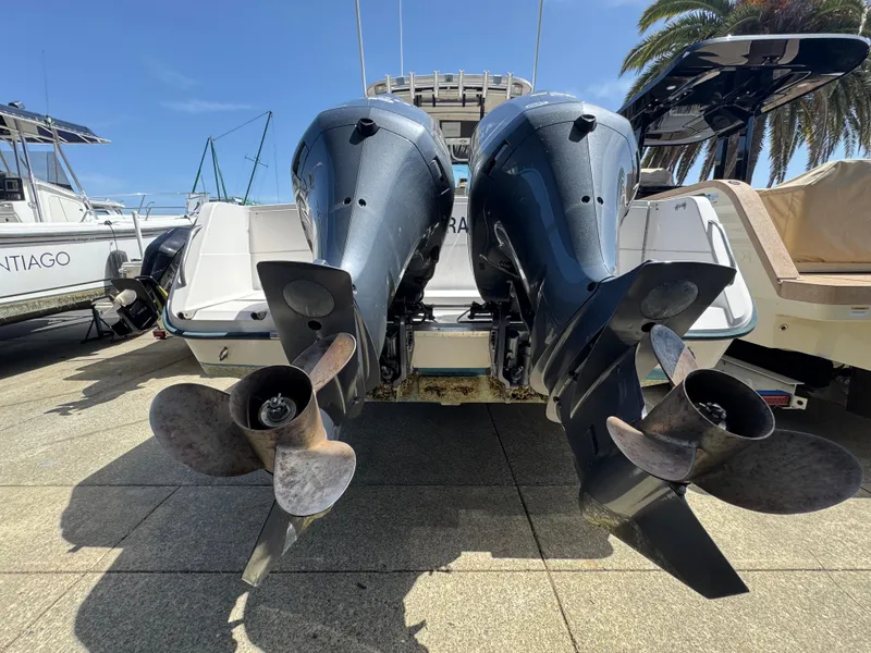 Slide: The Image of Twin outboard motors on a 1990 Grady-White Marlin 28 boat, docked under clear skies. - 1