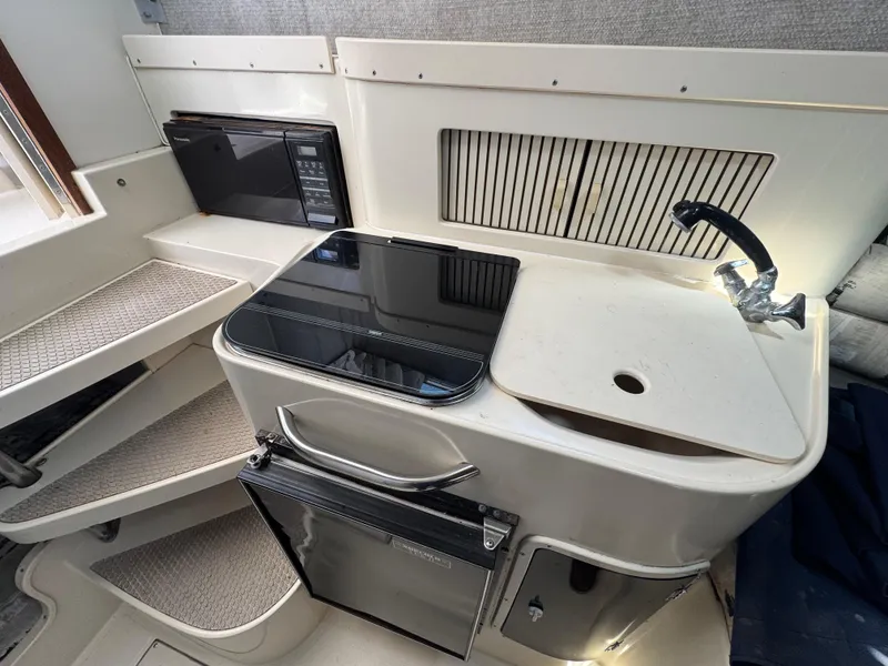 Slide: The Image of 1990 Grady-White Marlin 28 boat interior with kitchenette, sink, and microwave. - 14