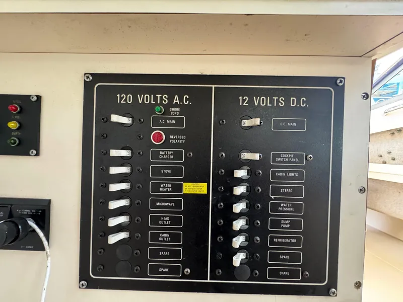 Slide: The Image of Electrical panel on a 1990 Grady-White Marlin 28 boat, showing 120V AC and 12V DC switches. - 16