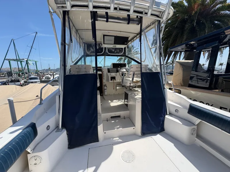 Slide: The Image of 1990 Grady-White Marlin 28 boat interior with seating and helm, docked at marina. - 22