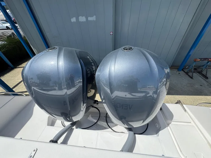Slide: The Image of Twin outboard motors on a 1990 Grady-White Marlin 28 boat, docked outdoors. - 23