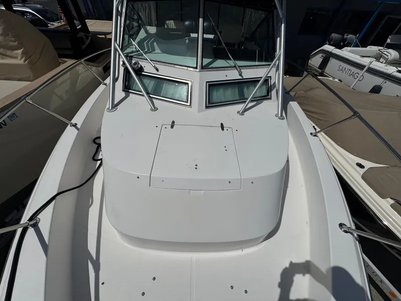 Slide: The Image of 1990 Grady-White Marlin 28 boat, front deck view, docked among other vessels. - 24